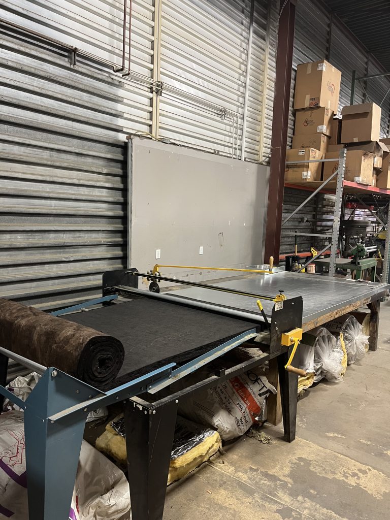 Insulation cutting table with roll of duct liner material