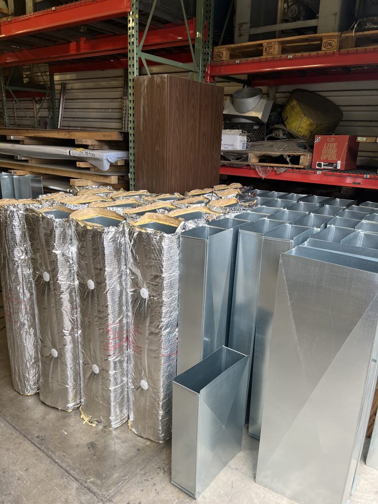 Insulated and bare sheet metal duct sections ready for installation